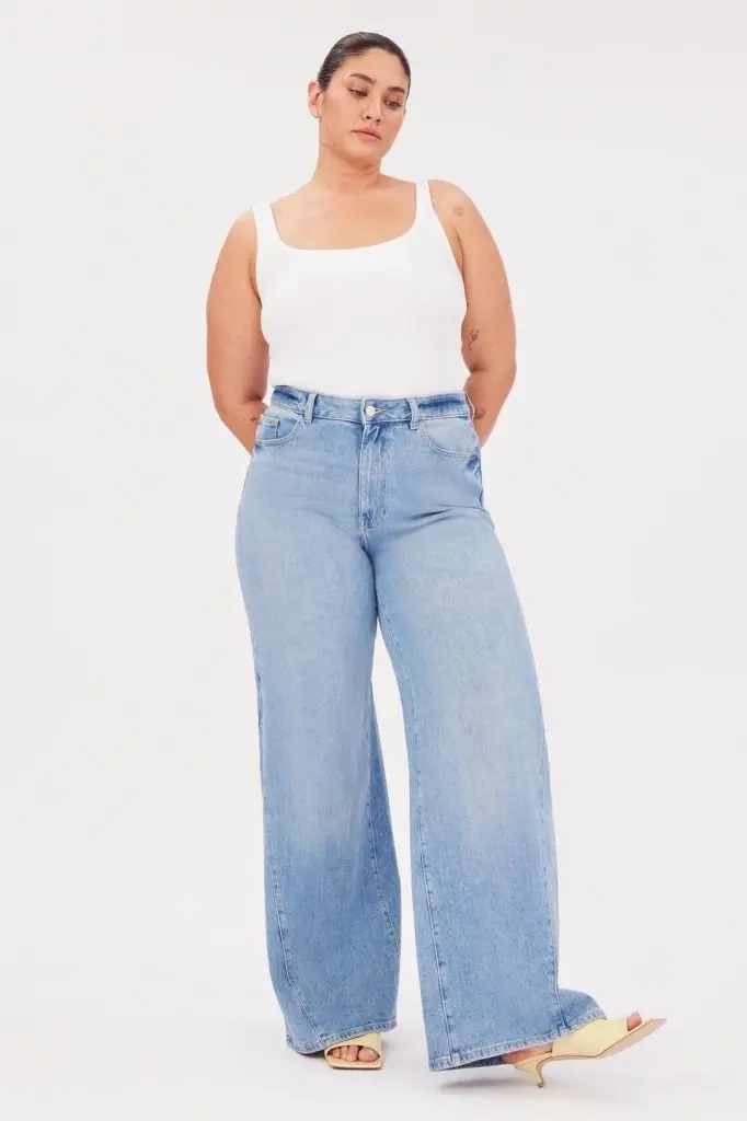 a curvy woman wearing a pair of light colored affordable sustainable jeans from warp + weft