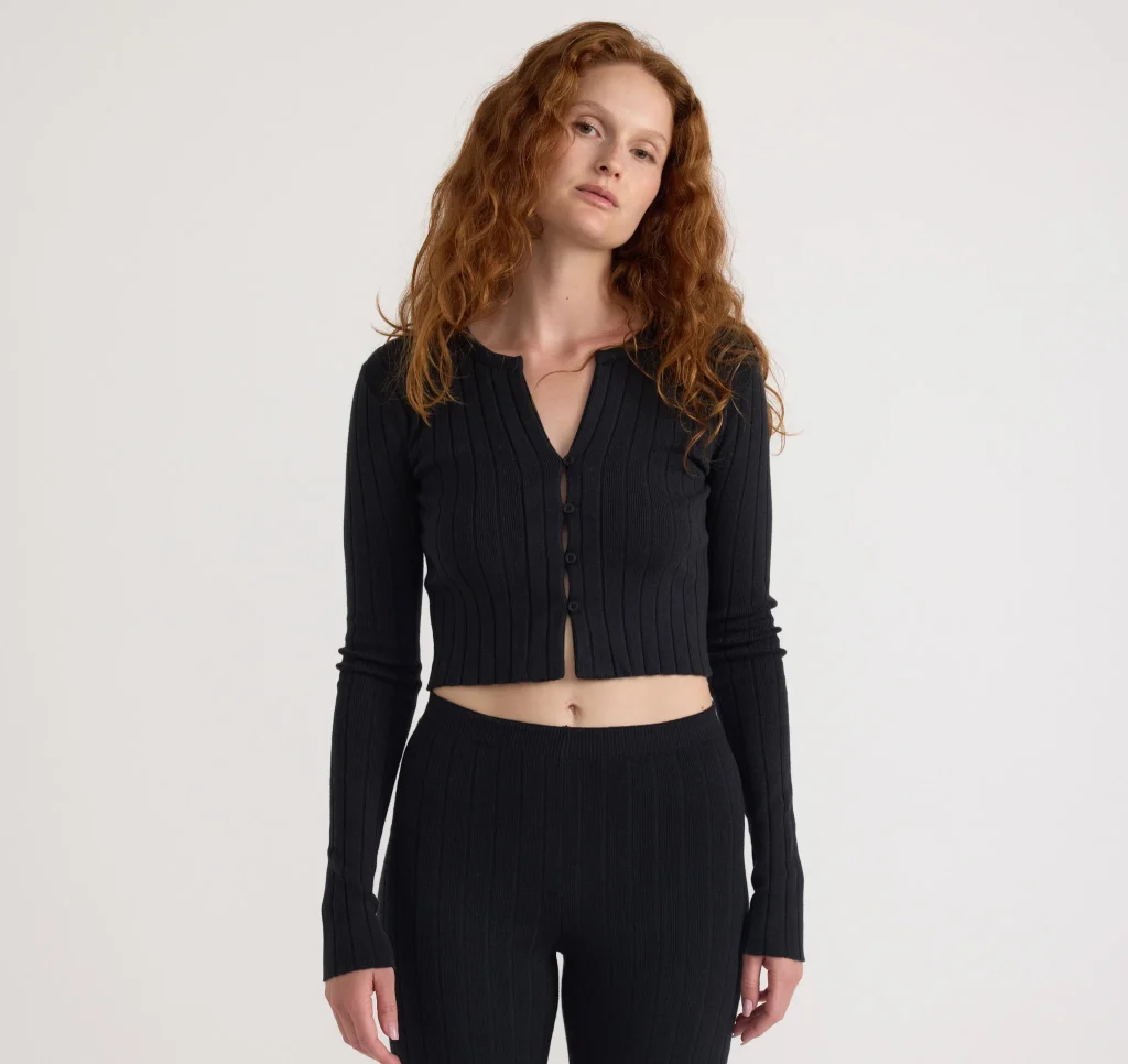 woman wearing an organic cotton black top from affordable sustainable clothing brand organic basics
