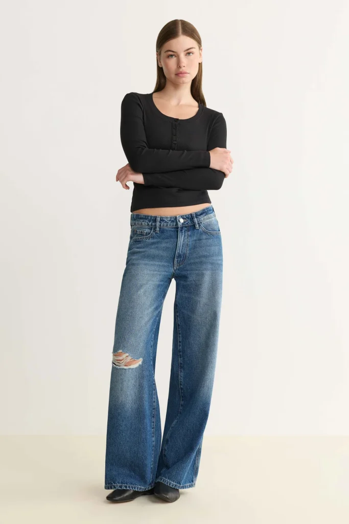woman wearing organic jeans and a black tshirt from affordable sustainable clothing brand warp + weft