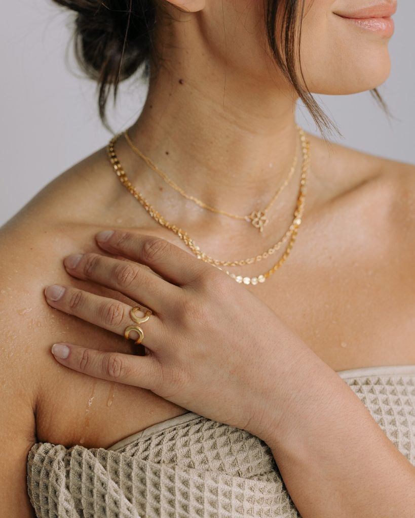 woman wearing sustainable rings and necklaces from affordable jewelry brand Laura Elizabeth