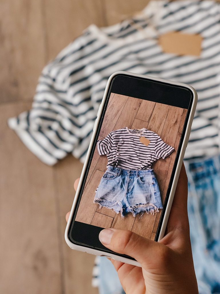 Woman taking picture of used clothes. Selling used clothes concept.