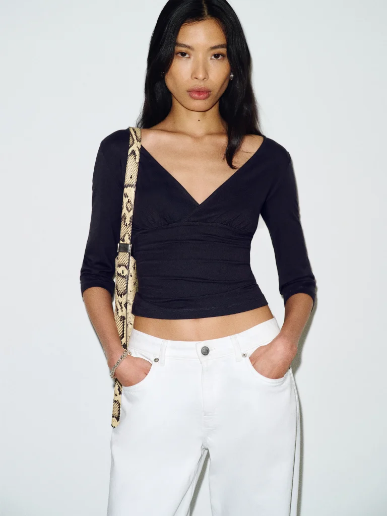 woman wearing a black top made from lyocell fabric from sustainable brand reformation